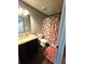 A bathroom with granite countertop vanity, decorative shower curtain, and dark stained cabinet at 300 Outlaw Rdg, Canton, GA 30115