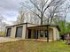 A cozy one-story home showcasing a covered porch and two garage doors, all in a natural setting at 300 Outlaw Rdg, Canton, GA 30115