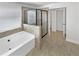 Bright bathroom features a soaking tub, shower with glass door, and a window at 2910 Blake Towers Ln, Buford, GA 30519