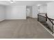 Open loft area featuring neutral carpeting, white walls, and decorative wrought iron railing at 2910 Blake Towers Ln, Buford, GA 30519