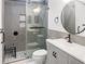 Bathroom featuring walk-in shower with tile accent, a vanity with black hardware, and round mirror at 475 Mount Vernon Ne Hwy # 226C, Atlanta, GA 30328