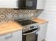Kitchen equipped with stainless steel oven, modern backsplash, and light wood countertops at 475 Mount Vernon Ne Hwy # 226C, Atlanta, GA 30328