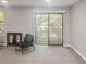 Living area with plush carpet, neutral paint, and sliding doors to a private patio at 475 Mount Vernon Ne Hwy # 226C, Atlanta, GA 30328