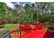 The vibrant red deck offers ample space for relaxing and enjoying the wooded views at 1791 Walker Sw Rd, Conyers, GA 30094