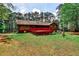 Expansive backyard with a bright red deck overlooking the peaceful and lush woodland at 1791 Walker Sw Rd, Conyers, GA 30094