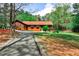 Quaint log cabin featuring a long asphalt driveway through a wooded lot at 1791 Walker Sw Rd, Conyers, GA 30094