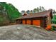 Three-car garage with log siding and ample concrete parking space at 1791 Walker Sw Rd, Conyers, GA 30094