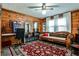 Living room featuring wood paneled walls, vintage furniture, and a decorative rug at 1791 Walker Sw Rd, Conyers, GA 30094