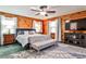 Cozy bedroom with wood walls, ceiling fan, TV, and carpet at 1791 Walker Sw Rd, Conyers, GA 30094