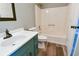 Well-lit bathroom with shower and tub combo, white toilet, and a teal vanity at 1810 Talbot Ct, Lawrenceville, GA 30044