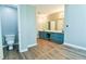 Large bathroom with double sinks, wood-look floors, and toilet at 1810 Talbot Ct, Lawrenceville, GA 30044