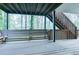 Covered wooden porch featuring a built-in bench and stairway access to the backyard at 1810 Talbot Ct, Lawrenceville, GA 30044