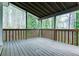 Covered wooden porch featuring a stained wood railing and views of the surrounding wooded lot at 1810 Talbot Ct, Lawrenceville, GA 30044