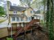 Back exterior view of the home with an expansive deck and stairs down to the backyard at 1810 Talbot Ct, Lawrenceville, GA 30044