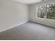 Bright bedroom with a large window, neutral walls and carpeting, and ample natural light at 7302 Par Four Way, Lithonia, GA 30038