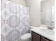 This bathroom features a modern vanity, white sink, decorative mirror and shower with decorative shower curtain at 485 Auburn Crossing Dr, Auburn, GA 30011