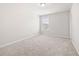 This bright, empty bedroom features neutral carpet, one window and a ceiling light at 485 Auburn Crossing Dr, Auburn, GA 30011