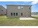 Exterior view of the back of a home with a patio and lush lawn at 485 Auburn Crossing Dr, Auburn, GA 30011