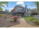 Back view of home with upper deck and lower patio overlooking landscaped backyard with stone path and stairs at 1025 Saint Marks Walk, Suwanee, GA 30024