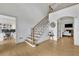 Bright foyer featuring hardwood floors, staircase with iron spindles, and access to a home office and living room at 1025 Saint Marks Walk, Suwanee, GA 30024