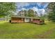 Well-maintained backyard featuring a brick patio, lush green lawn, and mature trees at 1283 Maple St, Conyers, GA 30013