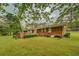 Well-maintained backyard featuring a brick patio, lush green lawn, and mature trees at 1283 Maple St, Conyers, GA 30013