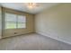 Neutral bedroom with ceiling fan, carpet, and window overlooking the home's grounds at 1283 Maple St, Conyers, GA 30013
