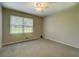 Neutral bedroom with ceiling fan, carpet, and window overlooking the outside at 1283 Maple St, Conyers, GA 30013