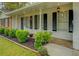 Welcoming front porch featuring manicured landscaping, black shutters, and decorative lighting at 1283 Maple St, Conyers, GA 30013