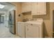 Functional laundry area with stainless steel refrigerator and white appliances, offering convenience and efficiency at 1283 Maple St, Conyers, GA 30013