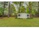 White backyard storage shed featuring double doors and situated on a lush, green lawn at 1283 Maple St, Conyers, GA 30013