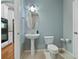 Compact bathroom with a pedestal sink, toilet and doorway to the kitchen at 1610 Apollo Dr, Suwanee, GA 30024