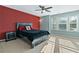 Bedroom with a black bed, a red accent wall, and windows providing natural light at 1610 Apollo Dr, Suwanee, GA 30024