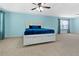 Spacious bedroom with light blue walls, a ceiling fan, a large white bed with blue accents, and carpeted floors at 1610 Apollo Dr, Suwanee, GA 30024