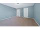 Empty bedroom featuring light blue walls, carpeted floors, and two open doorways at 1610 Apollo Dr, Suwanee, GA 30024