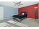 Bedroom with a black bed, a red accent wall, and windows providing natural light at 1610 Apollo Dr, Suwanee, GA 30024