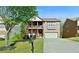 Beautiful two-story brick home featuring a covered balcony, lush green lawn and mature trees at 1610 Apollo Dr, Suwanee, GA 30024