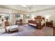 Spacious main bedroom featuring a large bed, sitting area, and elegant chandelier at 4195 Woodland Brook Se Dr, Atlanta, GA 30339