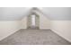 Finished attic space with neutral paint, carpeting and door to another room at 6493 Crooked Creek Pl, Lithonia, GA 30058