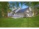Backyard with a large grassy area, stone patio and white house at 6493 Crooked Creek Pl, Lithonia, GA 30058