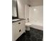 Elegant bathroom featuring black hexagonal tiles, a sleek vanity, and a shower-tub combo at 6493 Crooked Creek Pl, Lithonia, GA 30058