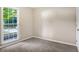Cozy bedroom featuring a large window offering natural light and plush carpeting at 6493 Crooked Creek Pl, Lithonia, GA 30058