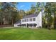 Charming two-story home featuring blue shutters, a well-manicured lawn, and mature trees in the background at 6493 Crooked Creek Pl, Lithonia, GA 30058