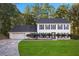 Charming two-story home featuring blue shutters, a well-manicured lawn, and an attached two-car garage at 6493 Crooked Creek Pl, Lithonia, GA 30058