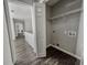 Well-lit laundry room with wooden floor, wire shelving, and washer and dryer hookups at 6493 Crooked Creek Pl, Lithonia, GA 30058
