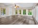 Bright sunroom with hardwood floors, many windows providing ample natural light, and a ceiling fan at 6493 Crooked Creek Pl, Lithonia, GA 30058