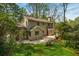 Back exterior view of house featuring deck, stone patio, and landscaped backyard at 6795 Brandon Mill Rd, Atlanta, GA 30328