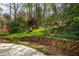Backyard with stone retaining wall and lush landscaping provides a serene and picturesque outdoor setting at 6795 Brandon Mill Rd, Atlanta, GA 30328