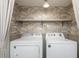 Bright laundry room featuring washer, dryer and decorative wallpaper at 6795 Brandon Mill Rd, Atlanta, GA 30328