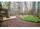 Beautifully landscaped backyard with a wooden deck and stone pathway amidst tall trees at 9176 Lakeview Parkway, Villa Rica, GA 30180